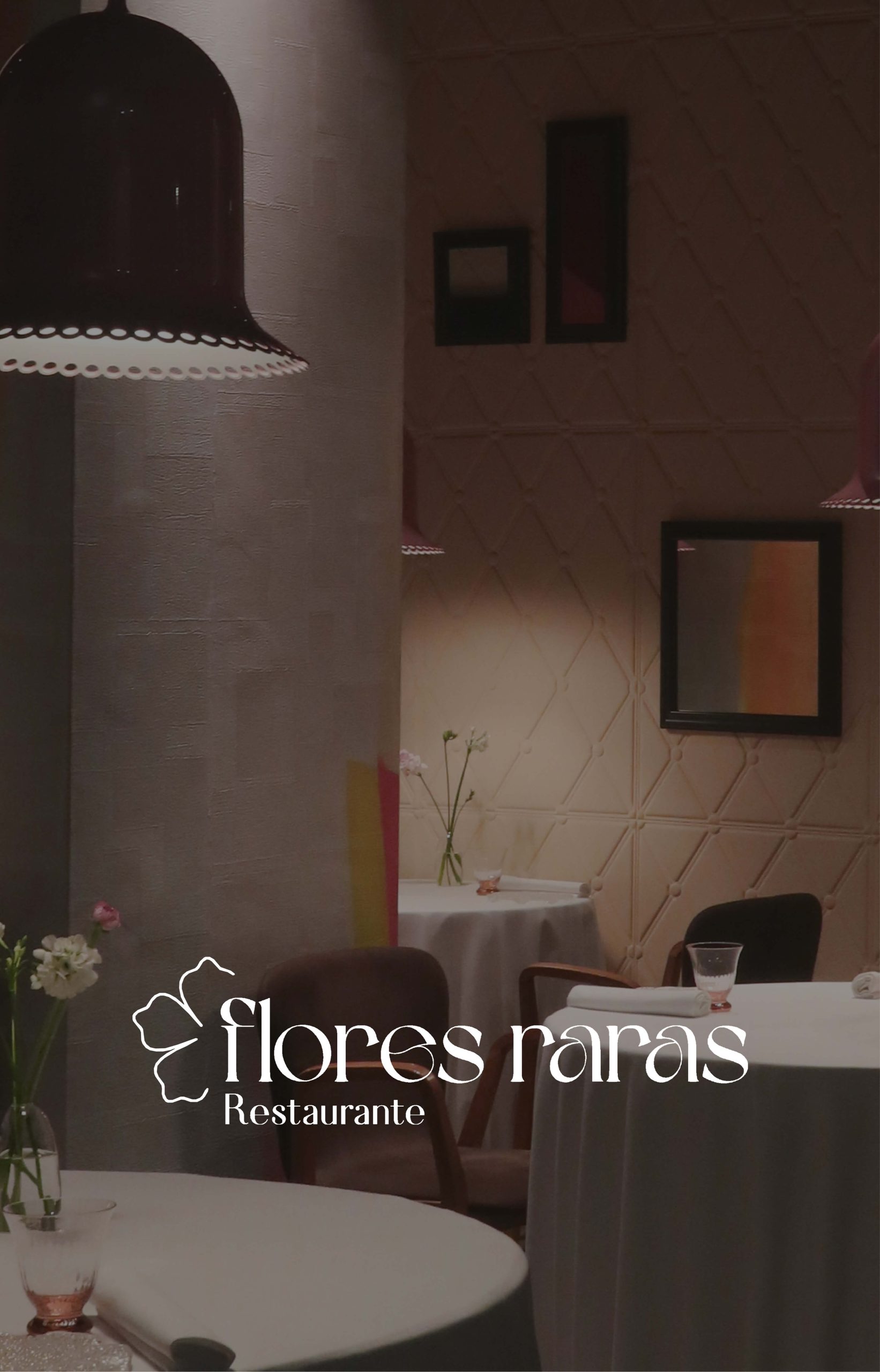Comedor de Flores Raras Restaurante con mesas vestidas de blanco, lámparas colgantes, flores y paredes decoradas en tonos cálidos.